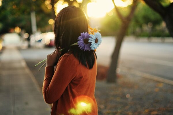 A girl with flowers on a city street