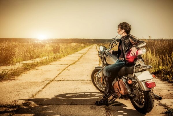 Девушка брюнетка на мотоцикле на дороге