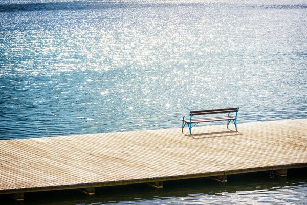 A bench for privacy on the pier against the background of the sea