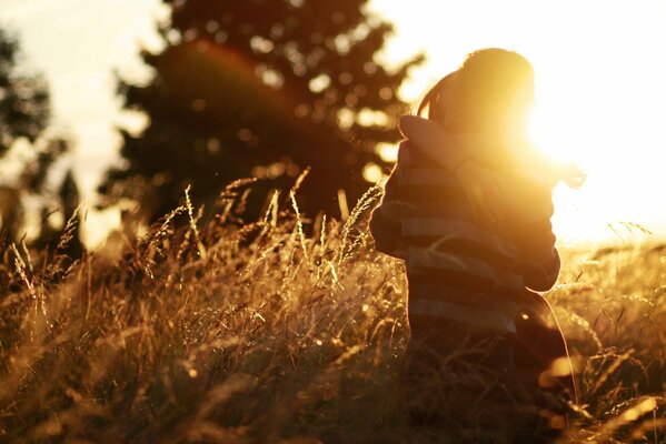 Pareja enamorada hombre y mujer en los brazos en el campo en el fondo del sol Poniente