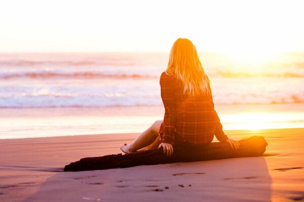 Una mujer se queda en la playa junto al río