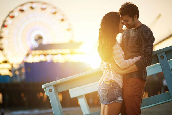 A couple of lovers on the background of a Ferris wheel