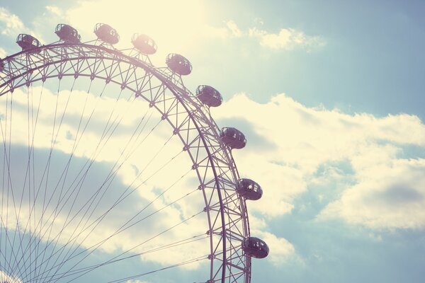 Ferris wheel attraction on the background of clouds