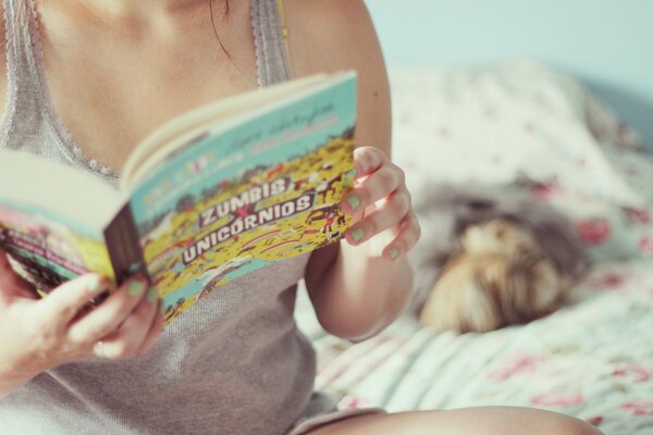 Fille sur le lit avec un livre dans les mains