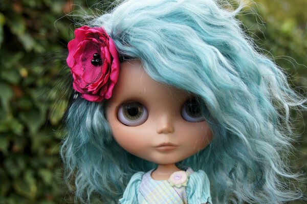 A doll with blue hair with a flower in her hair