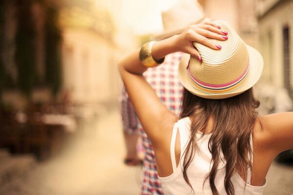 Fille en t-shirt blanc tient un chapeau