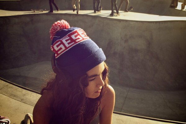 Chica rizada en un parque de skate soleado