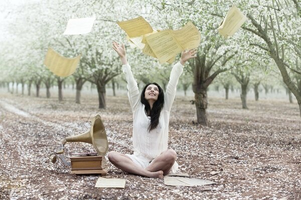 Jeune fille jette des notes à côté d un gramophone dans le jardin