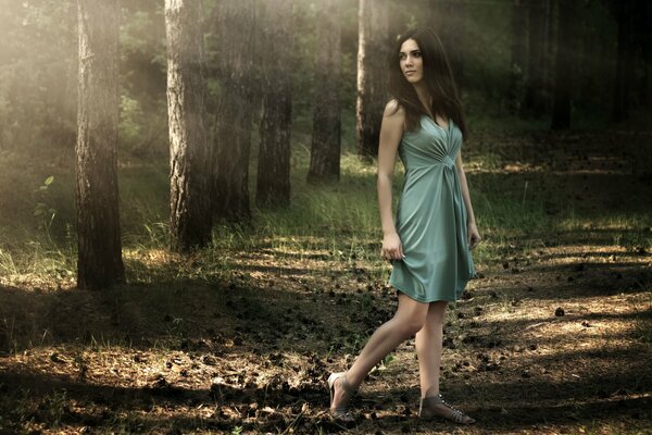 Fille en robe sur le chemin dans la forêt