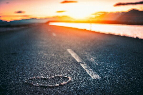 A heart made of stones on the background of sunset