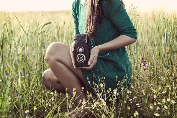 Fille dans l herbe tenant un appareil photo