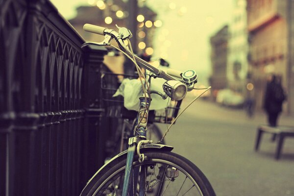 Велосипед у ограды на городской улице