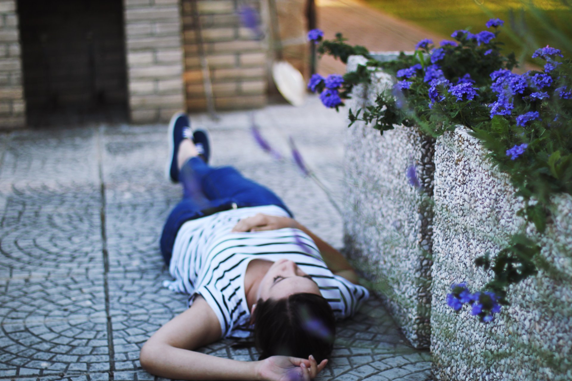 stimmung mädchen brünette liegt asphalt blumen blumen. natur hintergrund tapete