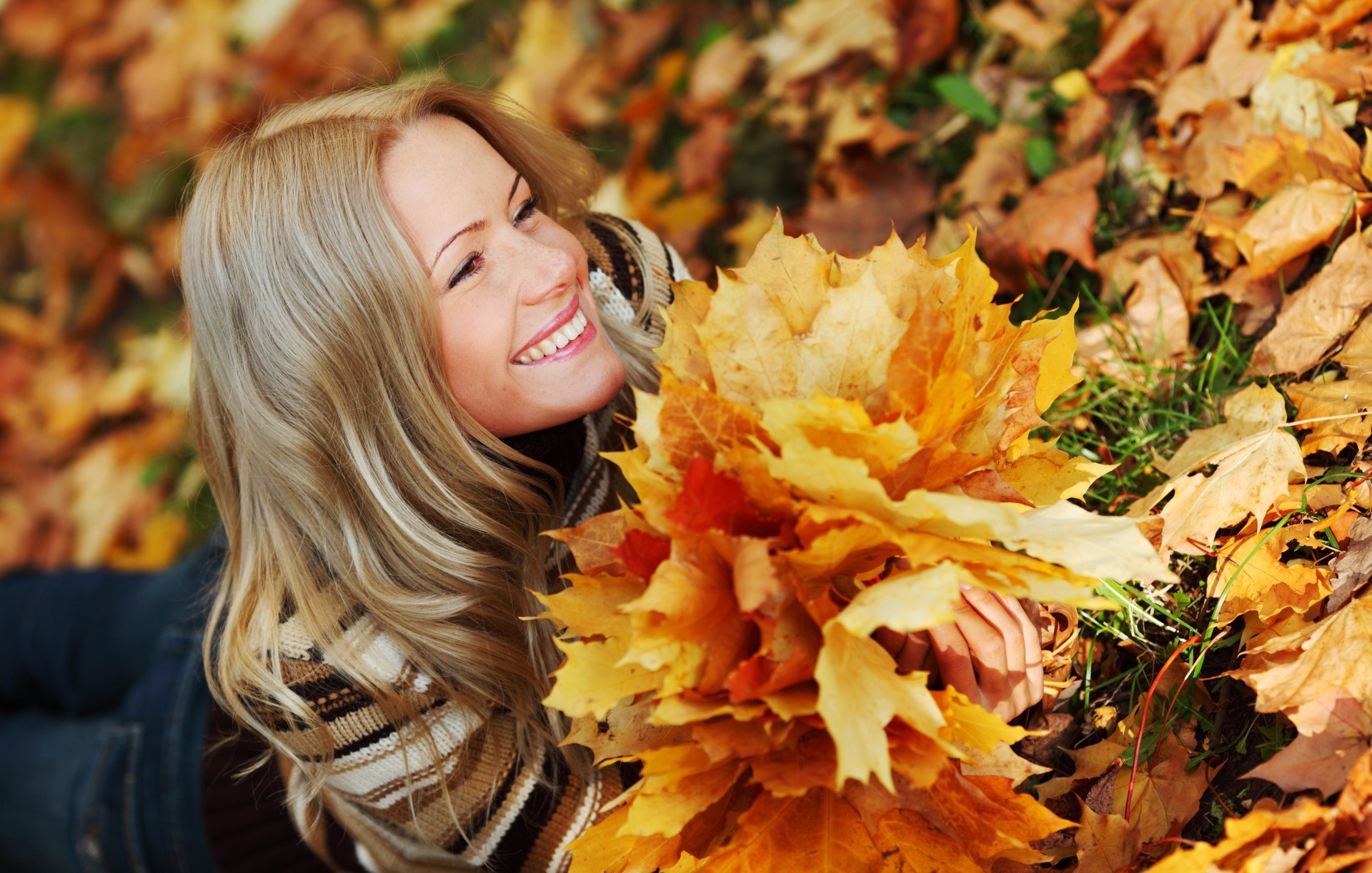 ragazza sorriso sguardo bionda si trova jeans maglione autunno erba foglie