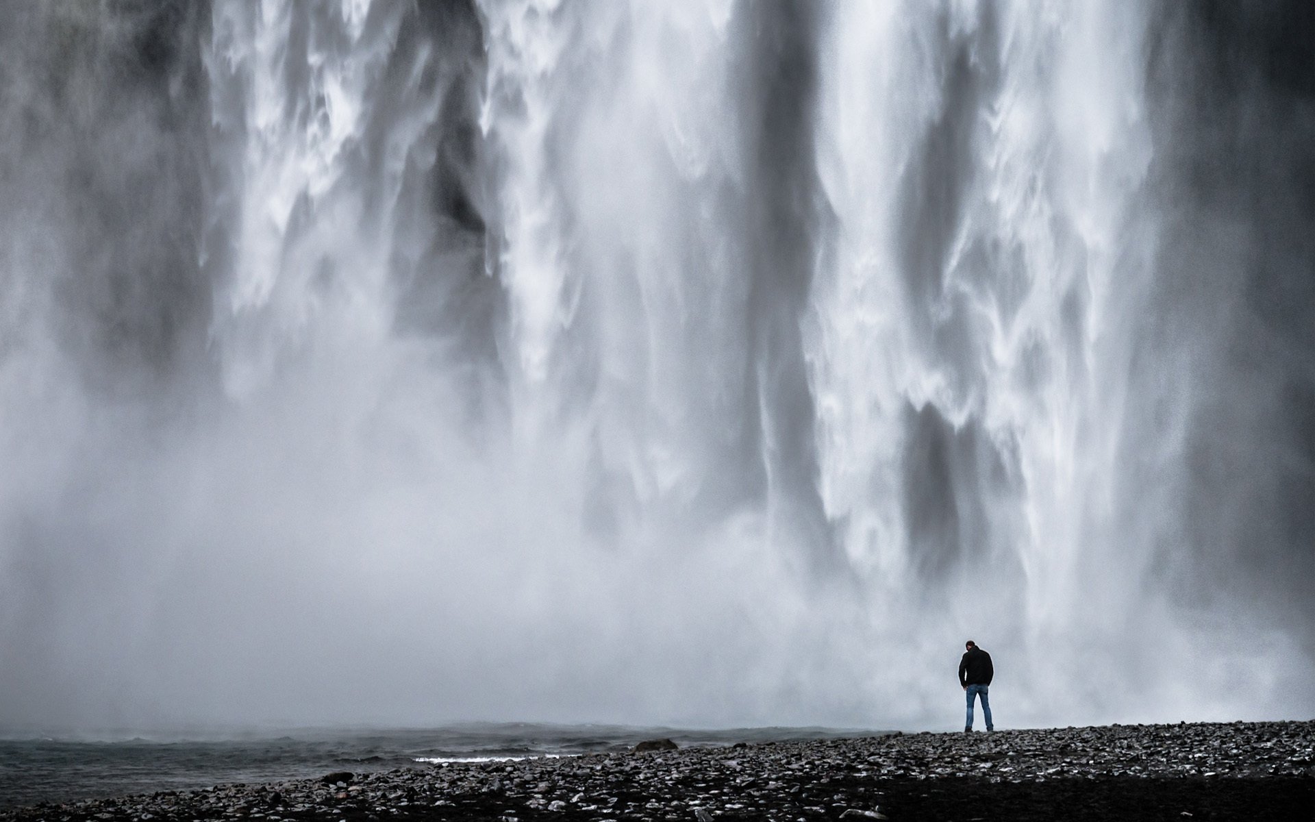 cascata uomo pietre acqua monocromatico bianco e nero