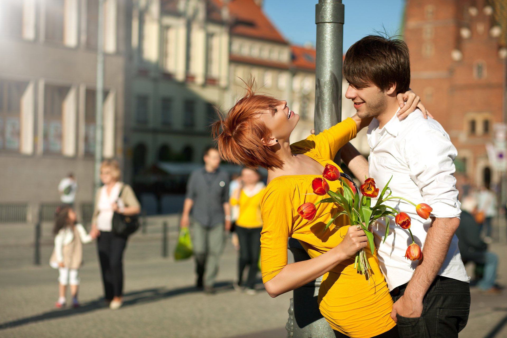 pareja novio chica pelirroja vestido sonrisas pilar ciudad gente flores ramo tulipanes positivo