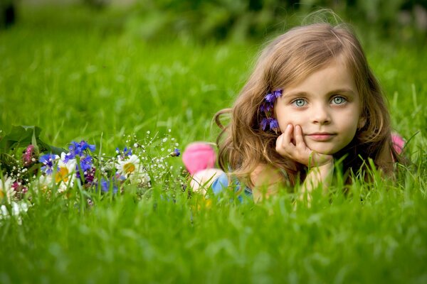 Una niña yace en un campo de flores