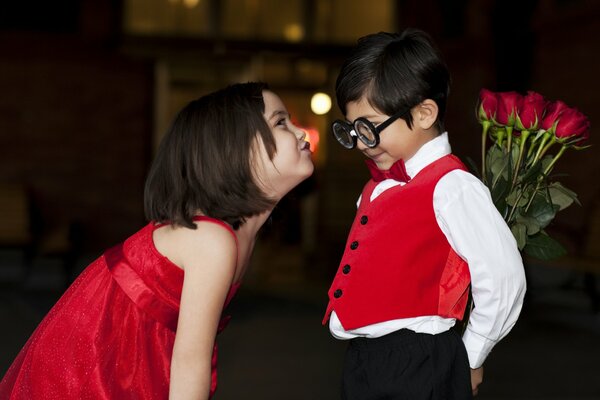 Niño con un ramo de rosas rojas