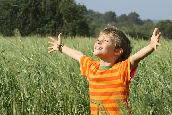 Ragazzo gioioso sul campo di segale verde