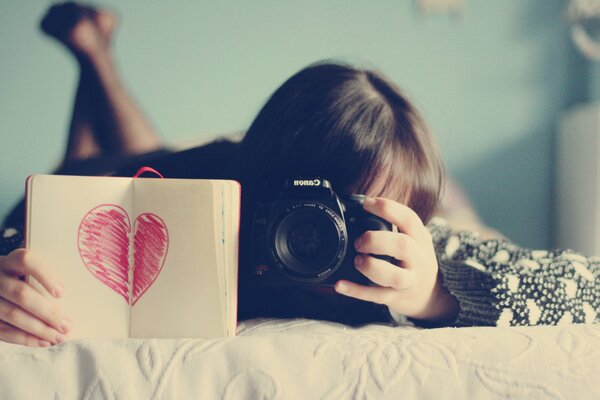 Una niña toma una foto de un Bloc de notas con una imagen de un corazón