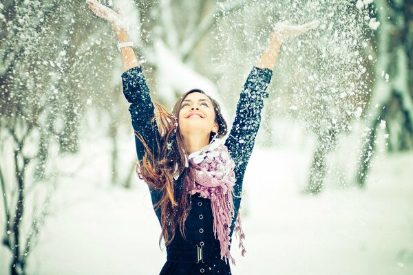 The girl throws snow over her head