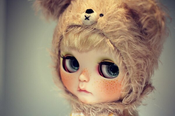 Puppe in der Kapuze eines Bären mit traurigen Augen