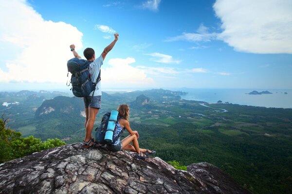 Chico y chica. Turistas en la cima con vistas al valle