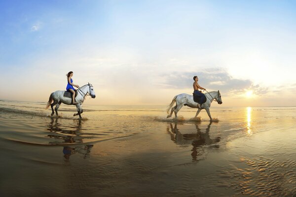 Paseo de los amantes a caballo por la orilla del mar