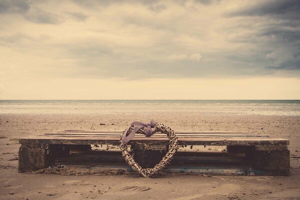 Un corazón olvidado en un banco junto al mar