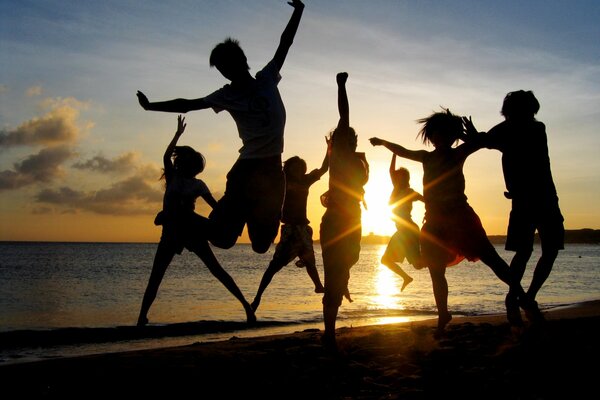 Jeunes sur la plage au coucher du soleil