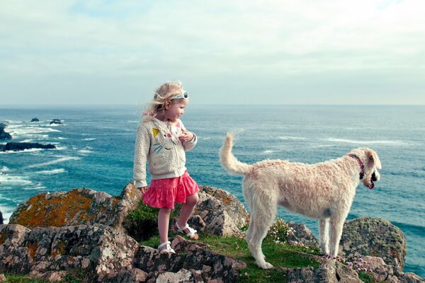 Ragazza con cane in riva al mare