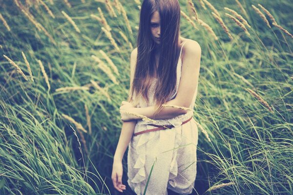 Ragazza con i capelli sciolti in piedi in un campo