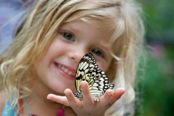 Fille bouclée se réjouit d un papillon