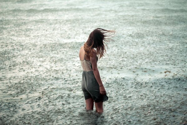 Ein einsames Mädchen kniet im Wasser unter der Meerenge