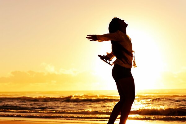 Silhouette d une jeune fille joyeuse sur fond de coucher de soleil de mer