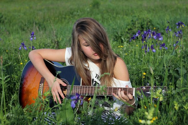 Ragazza con la chitarra alla radura estiva