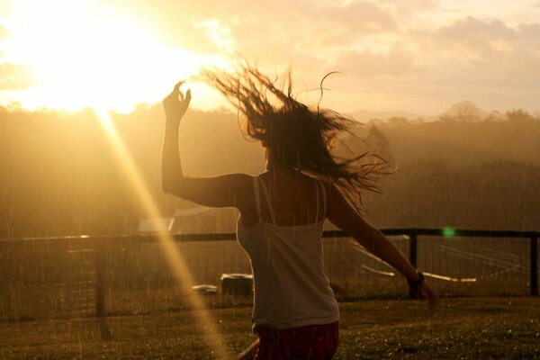 A girl running to meet the sun in the rain