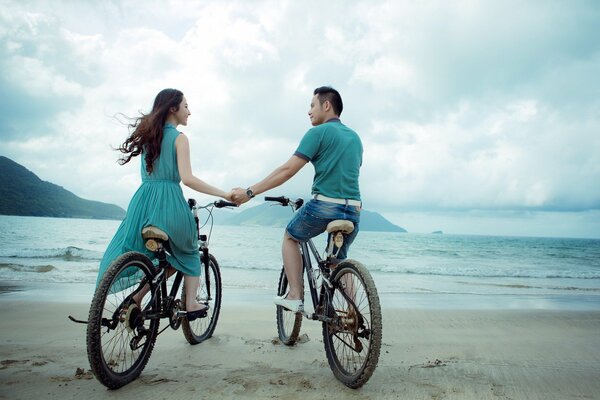 Lovers on bicycles on the seashore