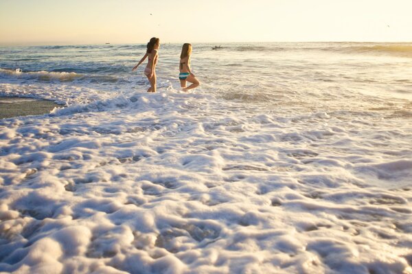 Girls running around the ocean