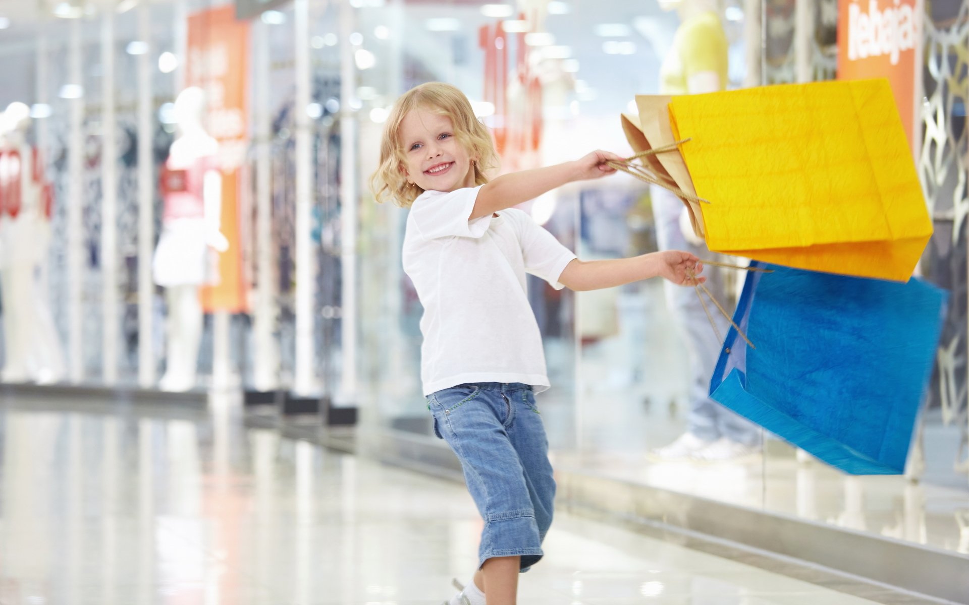 fille enfant joie bonheur sourire rire paquets shopping shopping jaune bleu