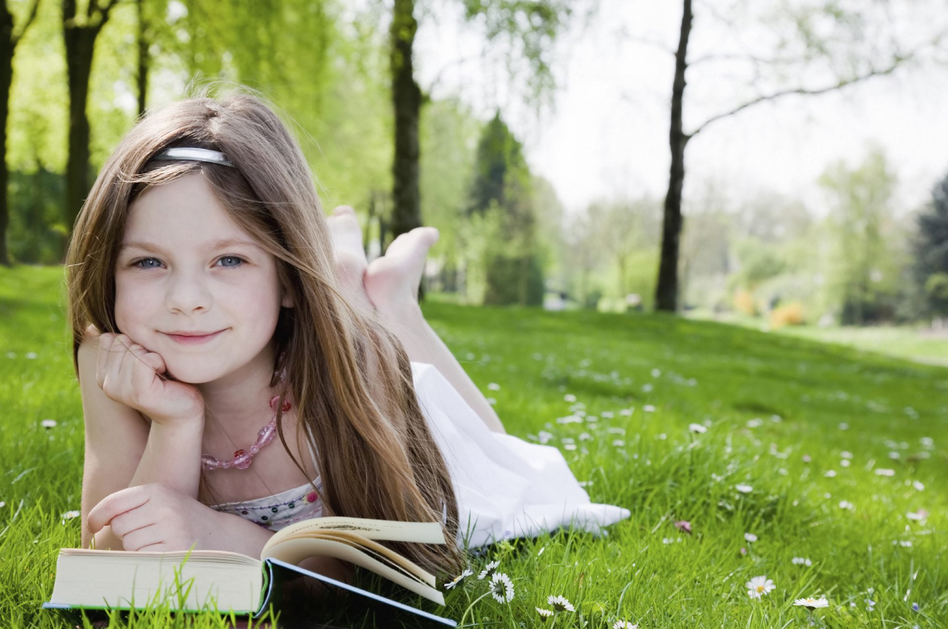 niedliche kleine mädchen niedlich hell glücklich freude glück lesen garten park bäume gras süße mädchen niedlich schön blond glücklich bücher kind kindheit kinder d