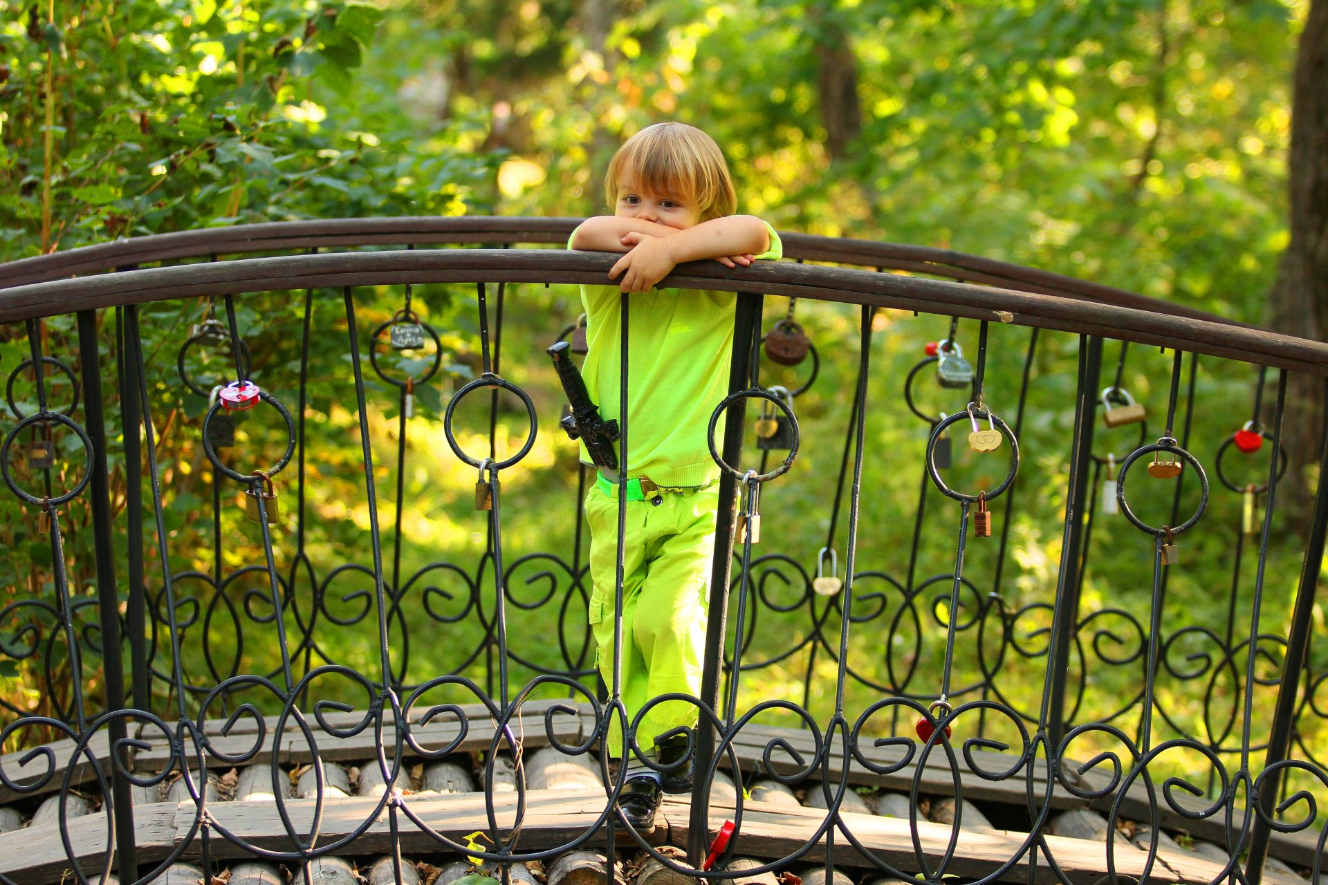 garçon enfant blond pose rêverie épée costume pont arbres clôture châteaux coeurs été verdure