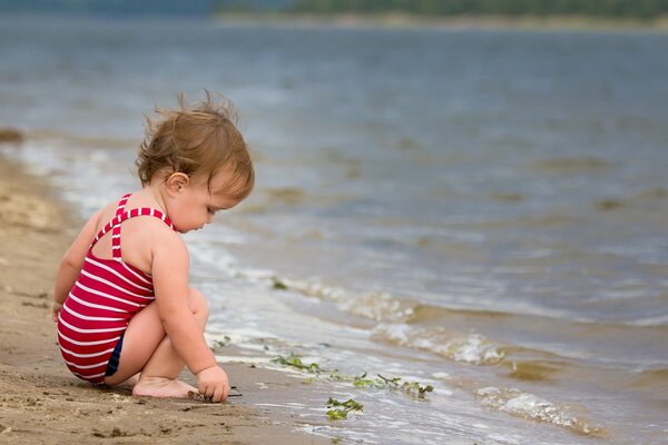 Le bébé est au bord de l eau. Mer douce