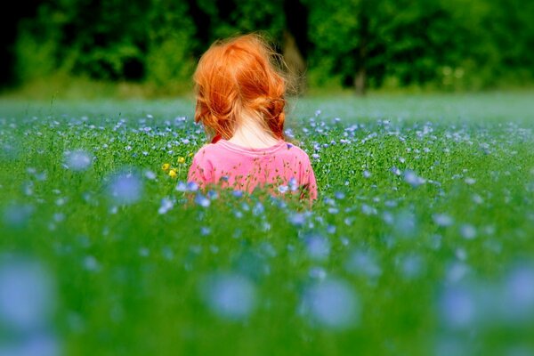 Солнечная девочка с рыжими волосами с реди травы