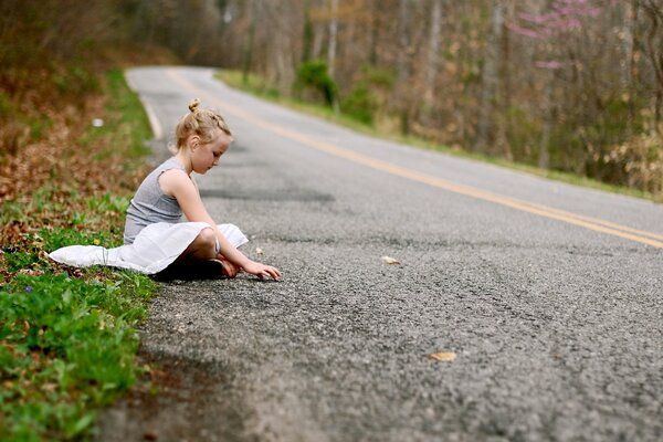 Fille assise sur la route