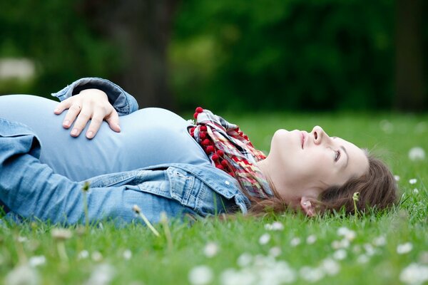 Pregnant girl on the green grass