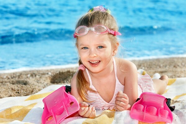 Glückliches kleines Mädchen im Sommer am Strand