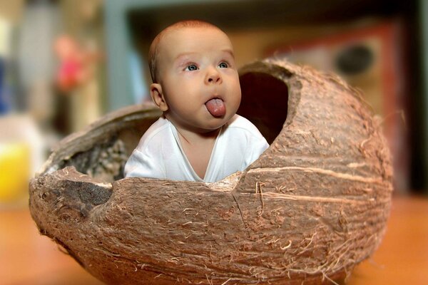 Nena muestra la lengua asomando fuera de la cáscara de coco