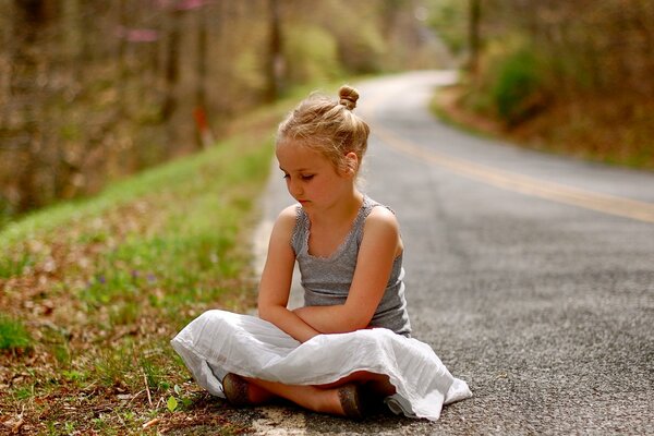 Ragazza seduta sulla strada