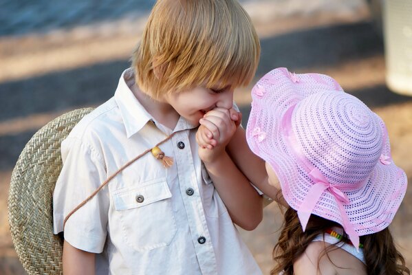 Un niño pequeño besa la mano de una niña